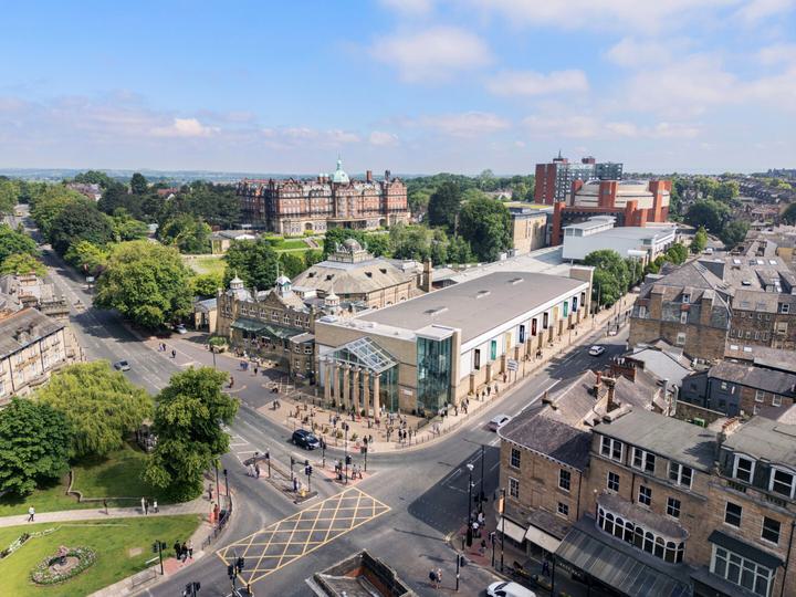 Aerial view of a vibrant cityscape featuring a mix of buildings and lush green trees interspersed throughout the area.