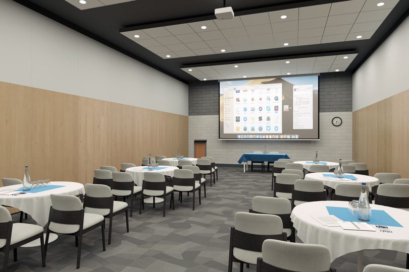 A spacious meeting room with projector and round tables in cabaret setting