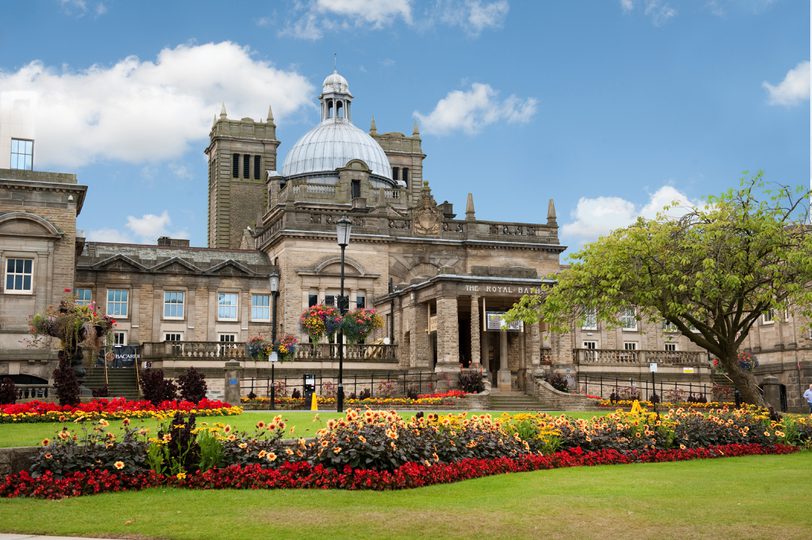 An elegant Victorian building with a dome and grand entrance and a sign "Royal Baths"